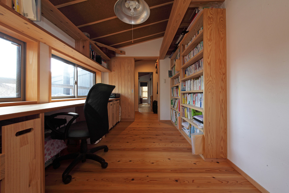 東京都下にあるモダンスタイルのおしゃれなホームオフィス・書斎 (白い壁、無垢フローリング、造り付け机、茶色い床) の写真