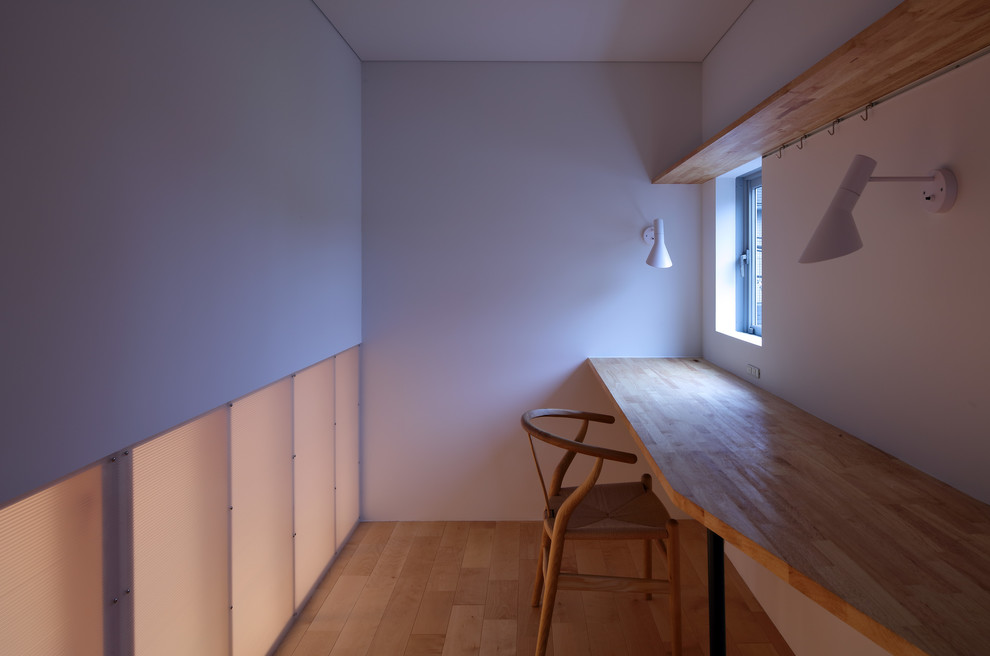 Foto de despacho nórdico de tamaño medio sin chimenea con paredes blancas, suelo de contrachapado, escritorio empotrado y suelo beige