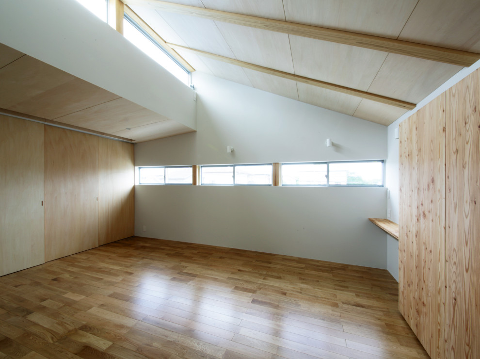 Cette photo montre une salle de sport scandinave multi-usage et de taille moyenne avec un mur blanc et un sol en bois brun.