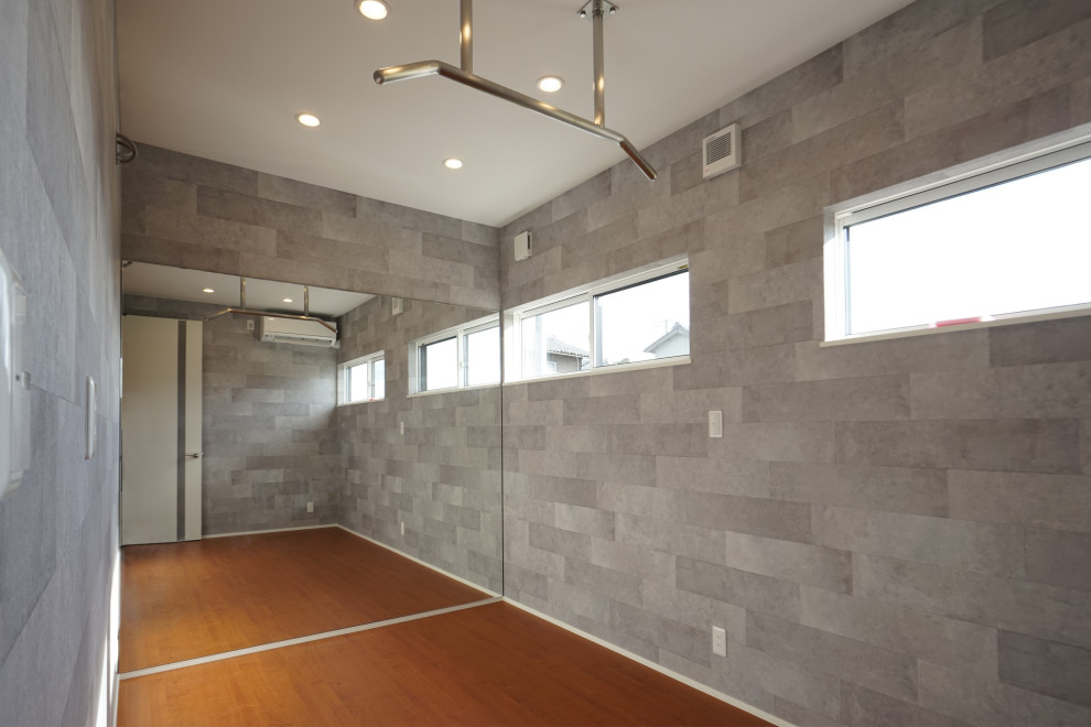 Exempel på ett mellanstort hemmagym med fria vikter, med grå väggar och brunt golv