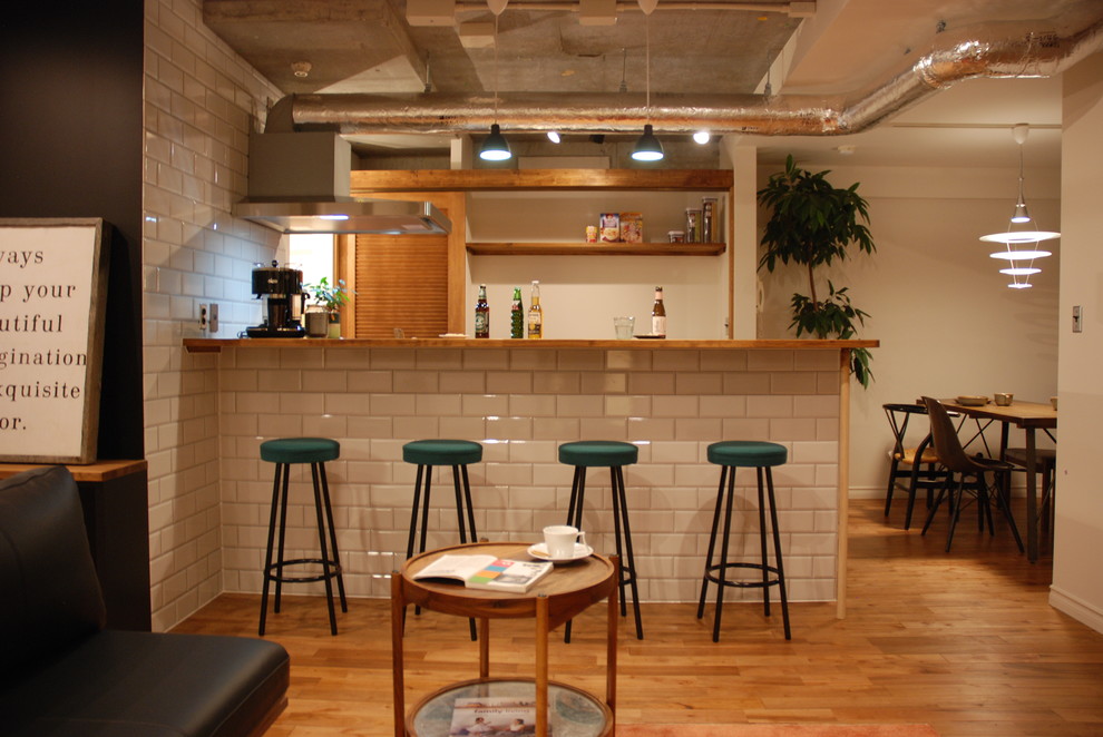 Imagen de bar en casa industrial con suelo de madera en tonos medios y suelo marrón
