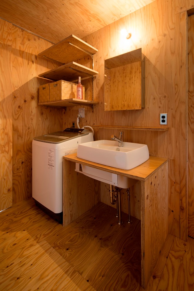 Idee per una lavanderia design con pareti marroni, pavimento in legno massello medio e pavimento marrone