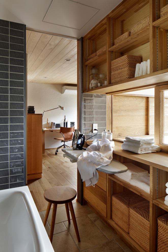 Idéer för en nordisk tvättstuga, med öppna hyllor, skåp i mellenmörkt trä, grå väggar och brunt golv