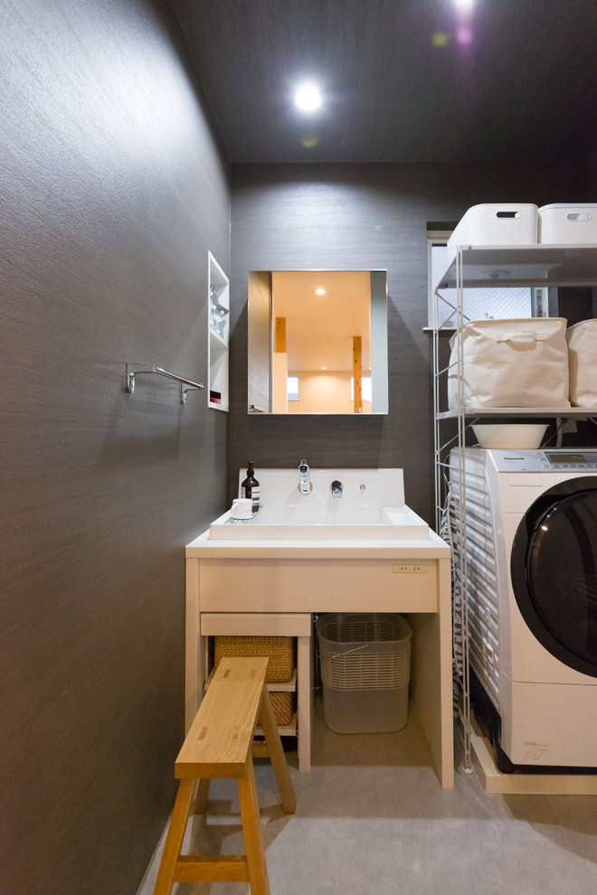 Esempio di una piccola lavanderia industriale con lavello da incasso, pareti grigie, pavimento in cemento e pavimento grigio