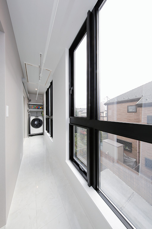 東京都下にあるお手頃価格の中くらいなインダストリアルスタイルのおしゃれな洗濯室 (I型、オープンシェルフ、白い壁、磁器タイルの床、洗濯乾燥機、白い床) の写真