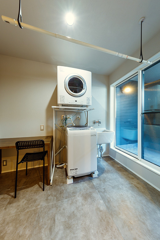 Пример оригинального дизайна: прямая универсальная комната среднего размера в стиле модернизм с белыми стенами, полом из керамогранита, с сушильной машиной на стиральной машине, бежевым полом, потолком с обоями и обоями на стенах