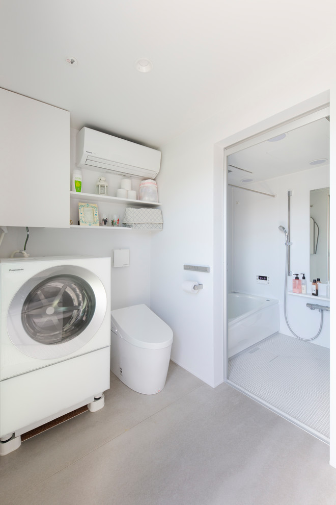 This is an example of a contemporary utility room in Tokyo with white walls and grey floors.