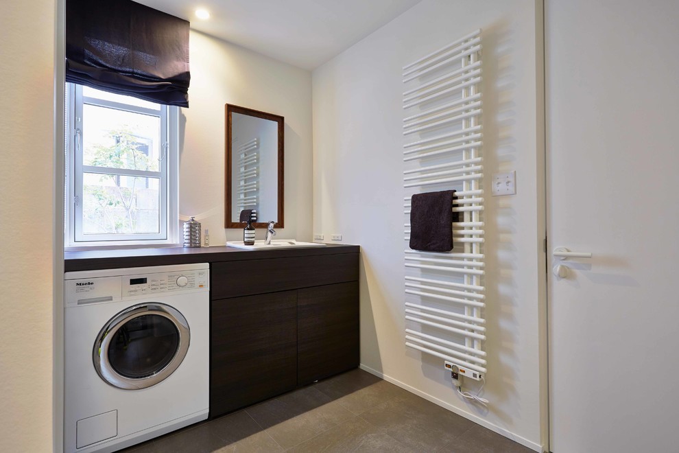 Imagen de lavadero escandinavo con paredes blancas y suelo gris
