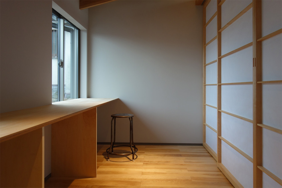 Inspiration pour une buanderie linéaire minimaliste en bois clair multi-usage avec un placard sans porte, un plan de travail en bois, un mur gris, parquet clair, des machines superposées et un plan de travail beige.