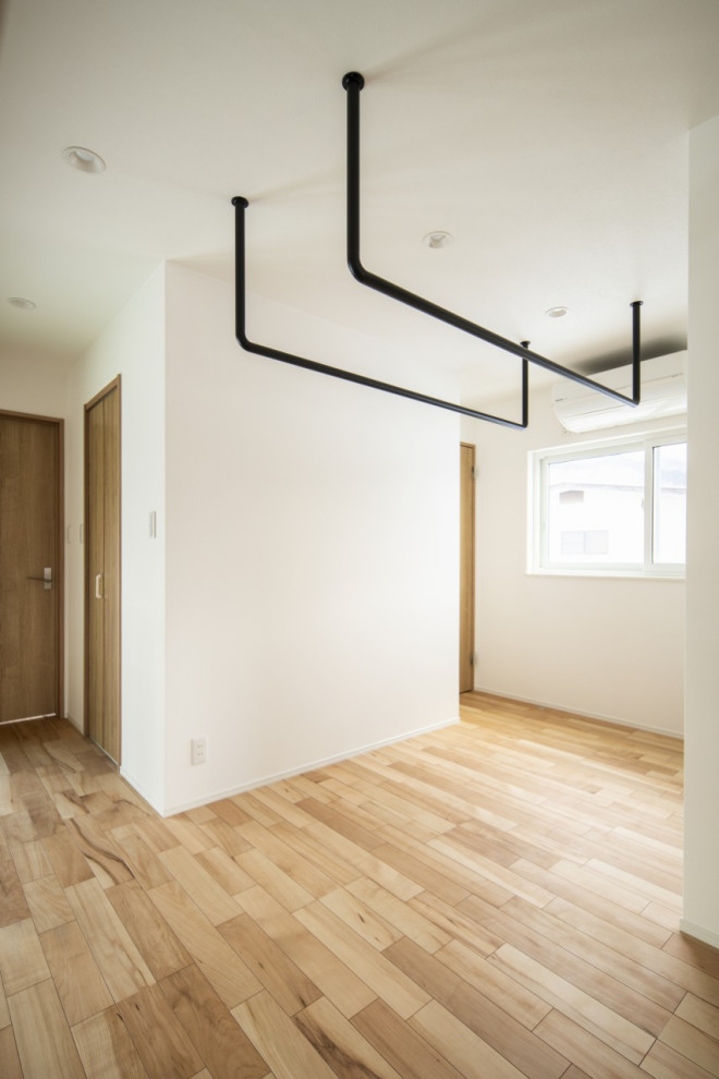 Multifunktionaler, Mittelgroßer Moderner Hauswirtschaftsraum mit weißer Wandfarbe, hellem Holzboden und beigem Boden in Sonstige