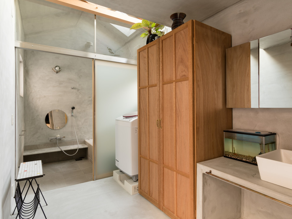Moderner Hauswirtschaftsraum mit Schrankfronten mit vertiefter Füllung, hellbraunen Holzschränken, grauer Wandfarbe und grauem Boden in Sonstige