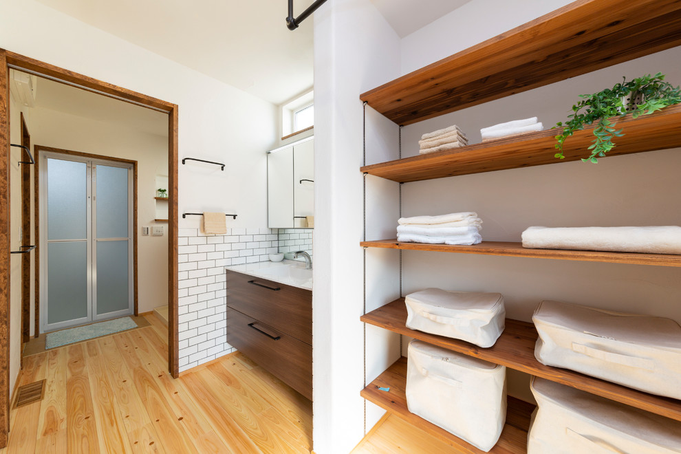 Multifunktionaler Industrial Hauswirtschaftsraum mit weißer Wandfarbe, braunem Holzboden und buntem Boden in Nagoya