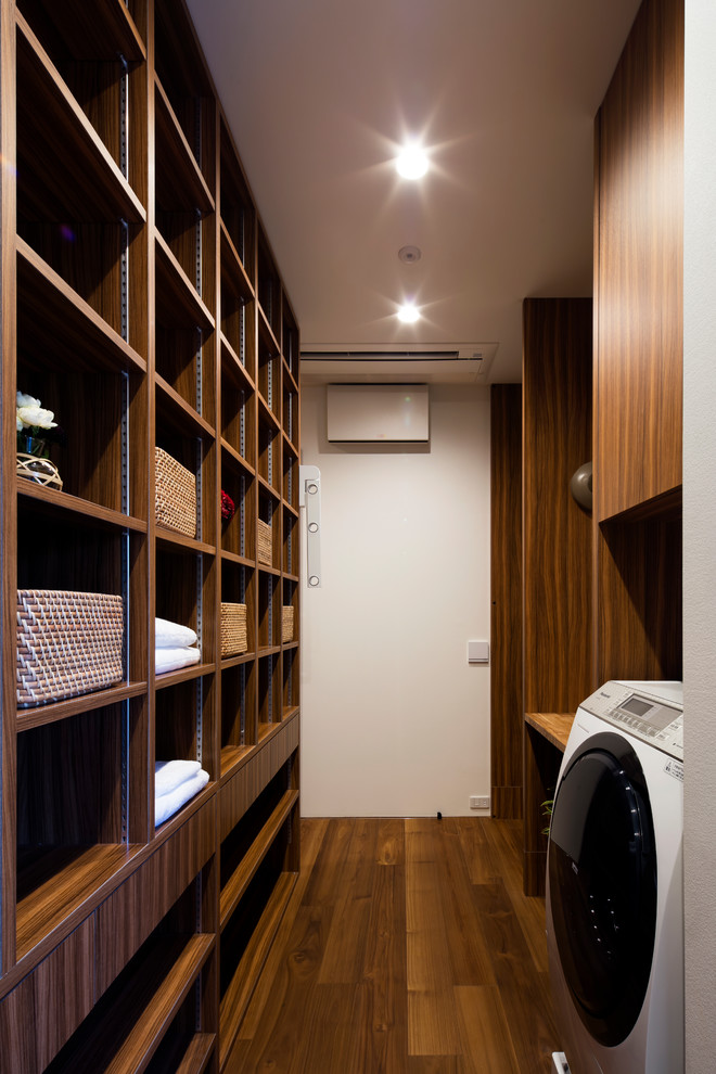 Ejemplo de lavadero contemporáneo con armarios abiertos, paredes blancas, suelo de madera en tonos medios y suelo marrón