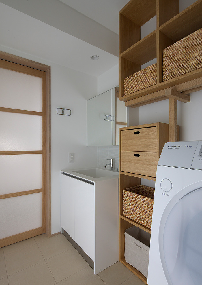 Idéer för en asiatisk linjär tvättstuga, med en integrerad diskho, öppna hyllor, skåp i mellenmörkt trä, vita väggar och beiget golv