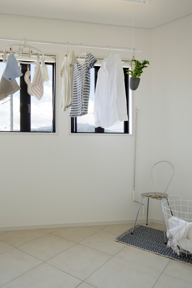 Imagen de cuarto de lavado minimalista grande con paredes blancas y suelo blanco