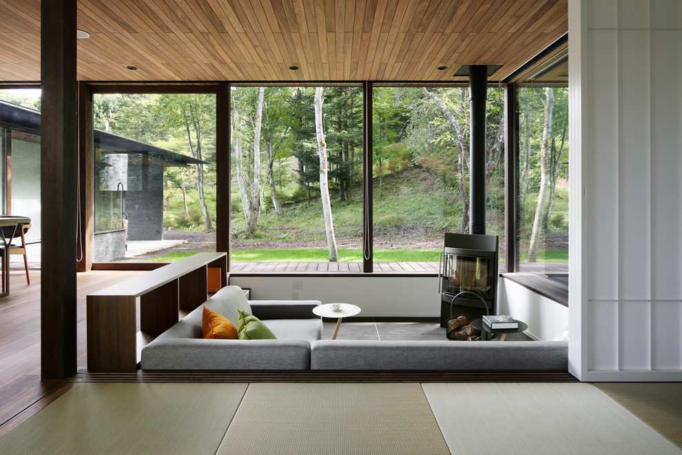 Exempel på ett asiatiskt vardagsrum, med tatamigolv, en öppen vedspis och grönt golv