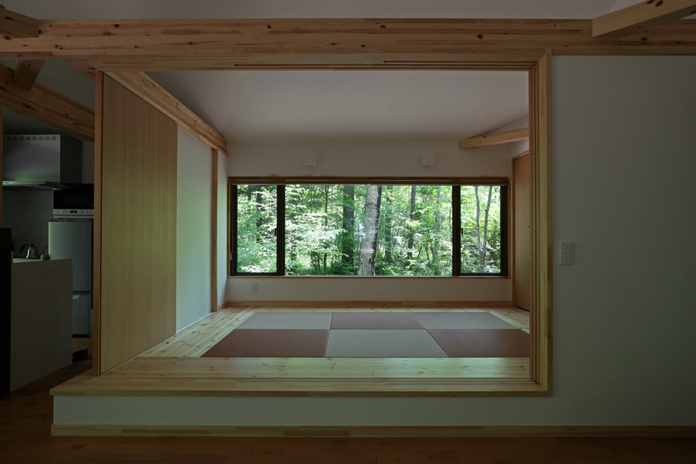This is an example of a farmhouse enclosed living room with tatami flooring.