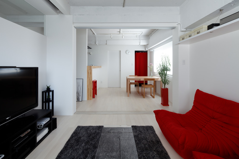 Kleines, Offenes Modernes Wohnzimmer mit weißer Wandfarbe, gebeiztem Holzboden, freistehendem TV und weißem Boden in Sonstige