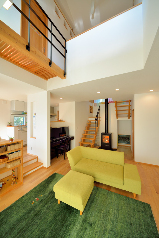 Ispirazione per un piccolo soggiorno etnico con pavimento in legno massello medio, stufa a legna, pareti bianche e pavimento beige