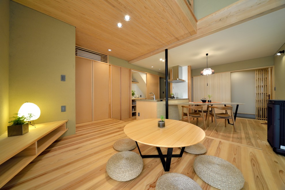 Offenes Asiatisches Wohnzimmer mit grüner Wandfarbe, braunem Boden und hellem Holzboden in Yokohama