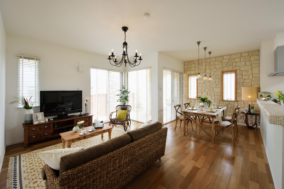 Foto de salón bohemio con paredes blancas, suelo de madera en tonos medios, televisor independiente y suelo marrón