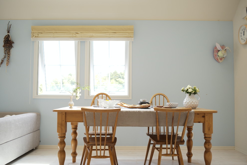 Cette image montre un salon nordique ouvert avec un mur bleu, parquet clair, un téléviseur indépendant et un sol blanc.