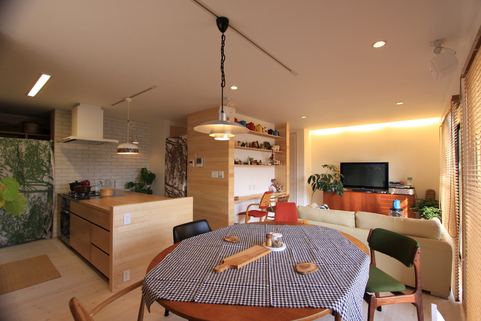 Asiatisk inredning av ett allrum med öppen planlösning, med vita väggar, ljust trägolv, en fristående TV och vitt golv
