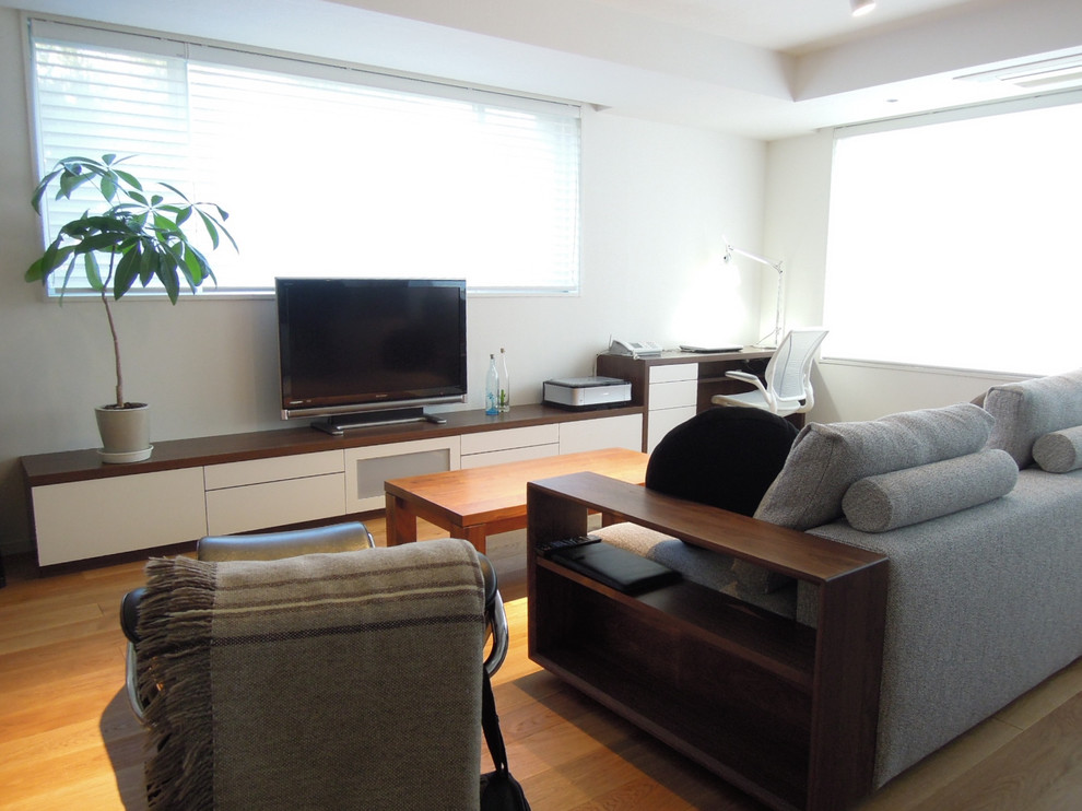 Exemple d'un salon moderne ouvert avec un mur blanc, un sol en bois brun, un téléviseur indépendant et un sol marron.