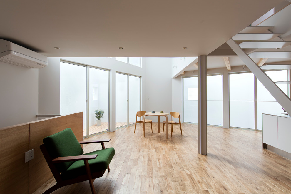 Imagen de salón actual sin chimenea y televisor con paredes blancas, suelo de madera en tonos medios y suelo beige