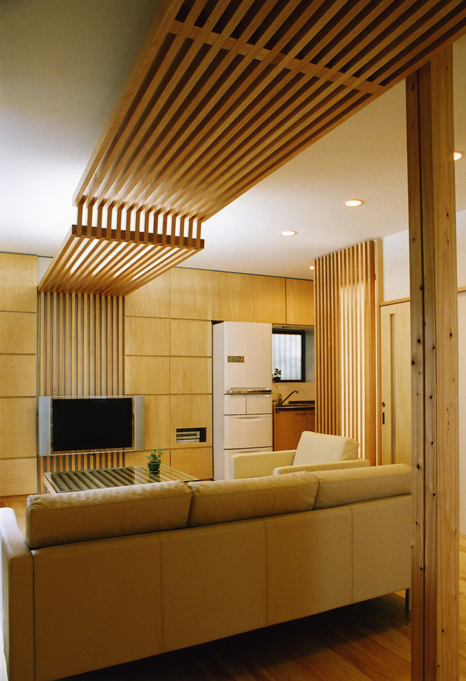 Exempel på ett asiatiskt allrum med öppen planlösning, med beige väggar, mellanmörkt trägolv och en väggmonterad TV