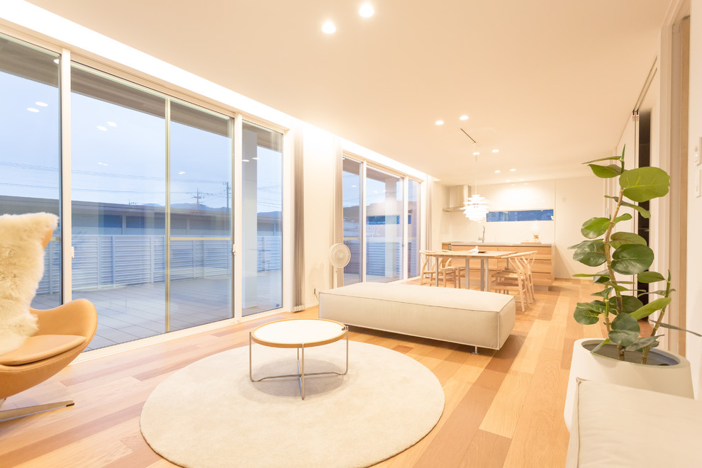 Foto de salón para visitas abierto nórdico con paredes blancas, suelo de madera clara y televisor colgado en la pared