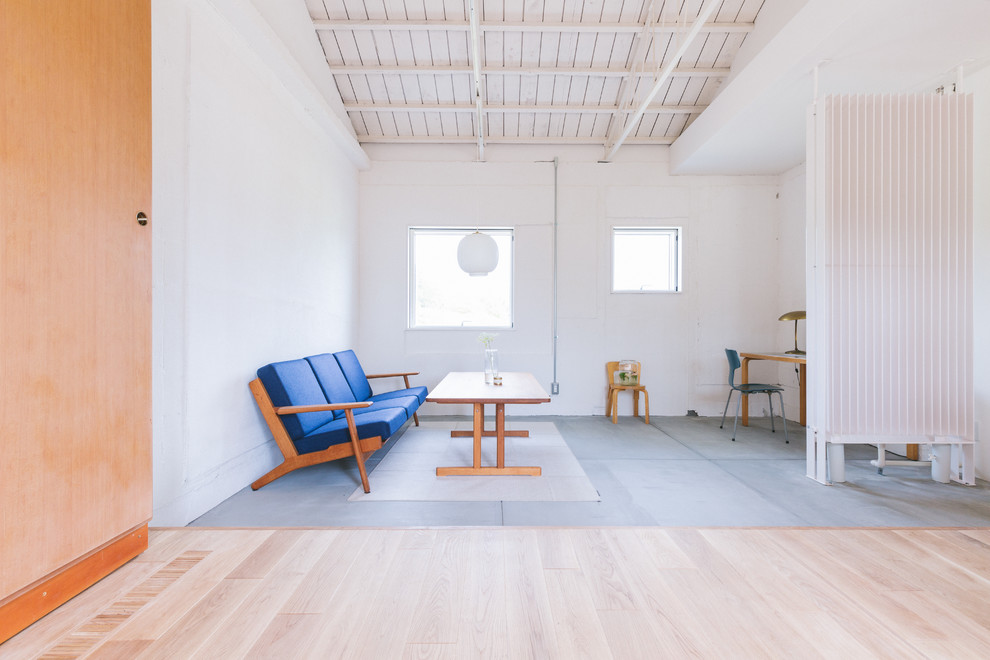 Esempio di un piccolo soggiorno nordico aperto con pareti bianche, pavimento in cemento e pavimento grigio