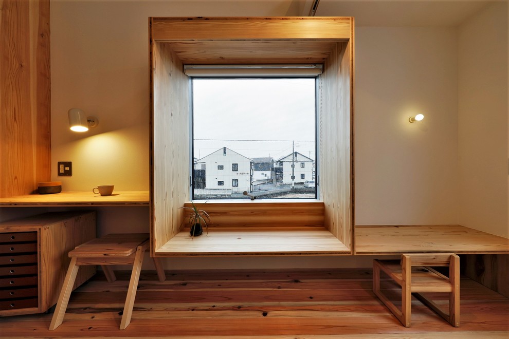 Cette photo montre un petit salon asiatique ouvert avec un mur blanc, un sol en bois brun, aucune cheminée, un téléviseur indépendant et un sol marron.