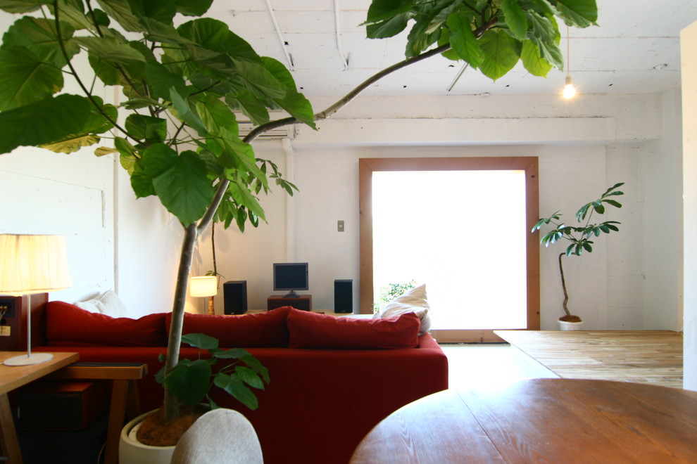 Diseño de salón abierto minimalista con paredes blancas, suelo de madera clara y televisor independiente