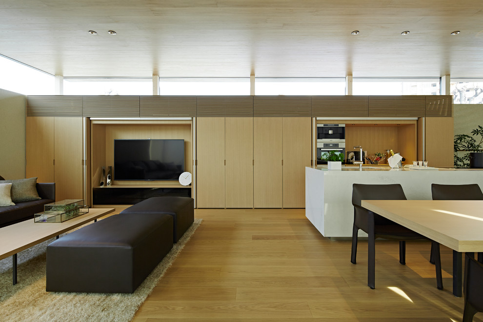 Inspiration för ett funkis allrum med öppen planlösning, med vita väggar, plywoodgolv, en dold TV och beiget golv