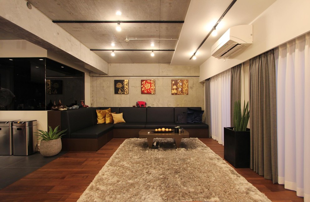 Asiatisk inredning av ett vardagsrum, med grå väggar, mellanmörkt trägolv och brunt golv