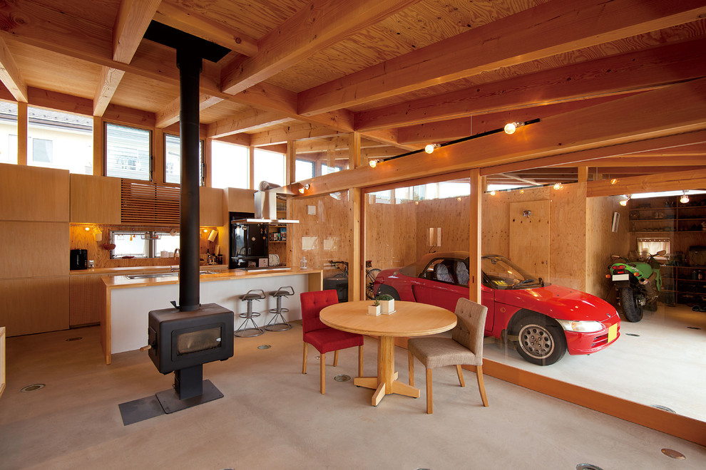 Imagen de salón asiático pequeño con suelo de cemento, estufa de leña, marco de chimenea de madera y paredes marrones