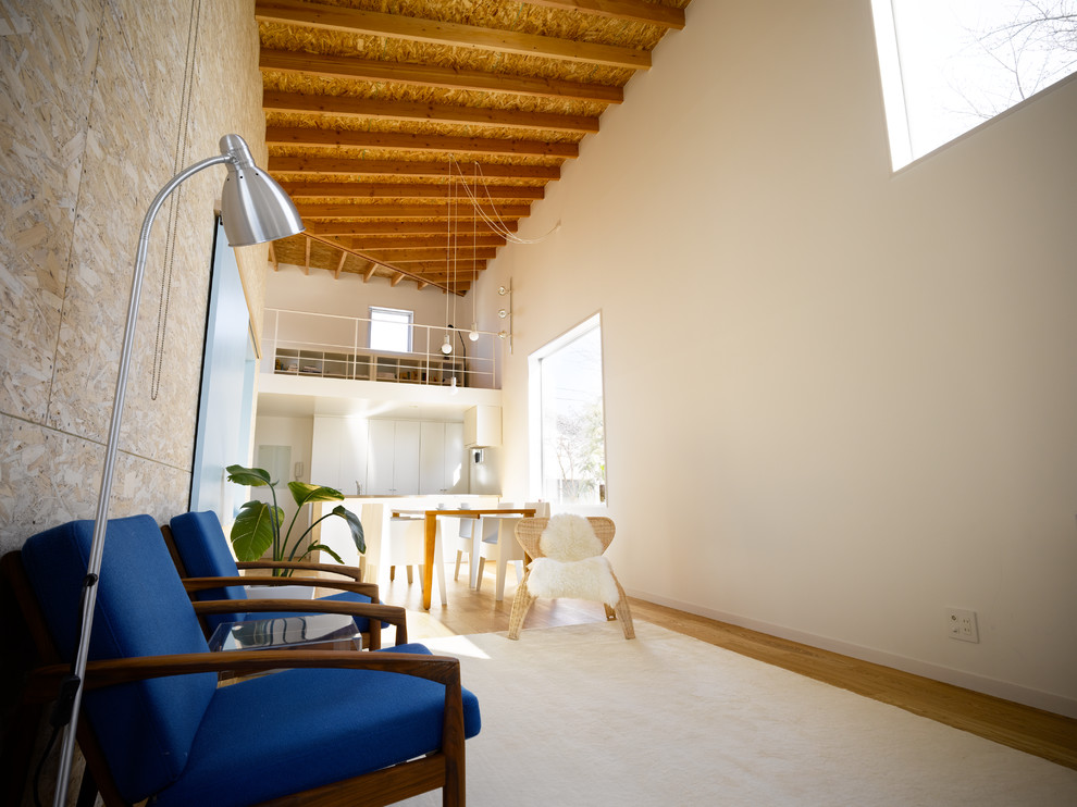 Cette image montre un grand salon minimaliste avec un bar de salon, un mur blanc, un sol en contreplaqué, un téléviseur indépendant et un sol marron.