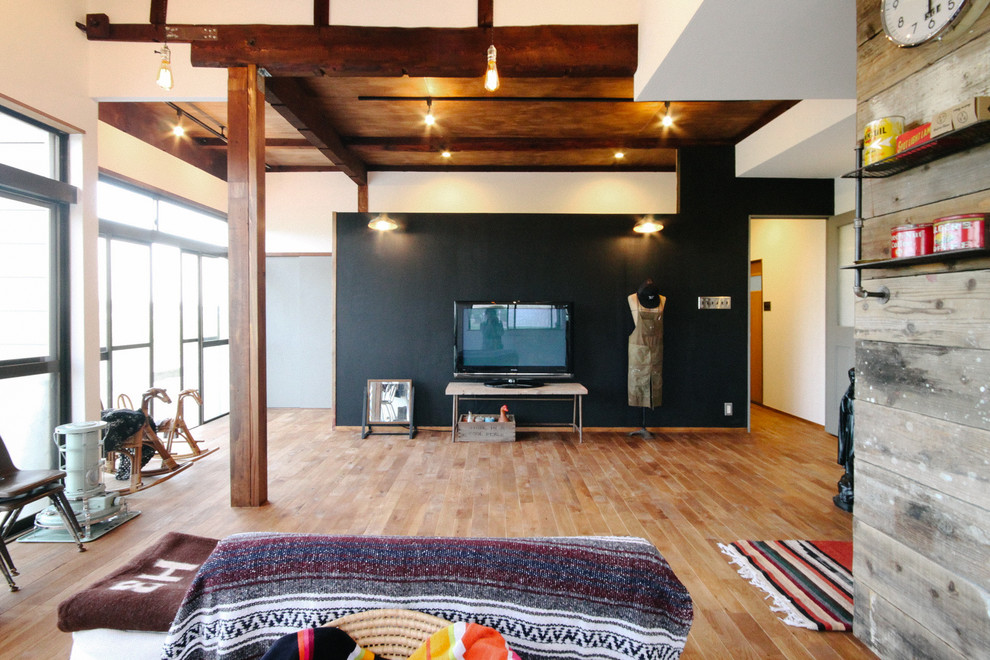 Стильный дизайн: гостиная комната в стиле фьюжн с разноцветными стенами, паркетным полом среднего тона, отдельно стоящим телевизором и коричневым полом - последний тренд