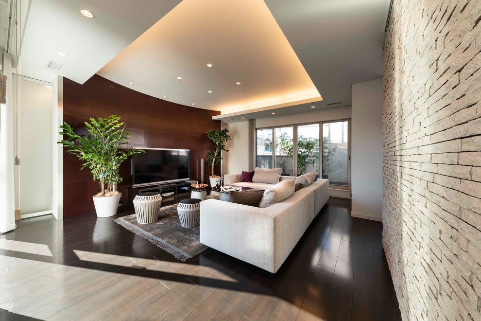 Идея дизайна: большая открытая гостиная комната в стиле модернизм с белыми стенами, полом из фанеры, отдельно стоящим телевизором и коричневым полом
