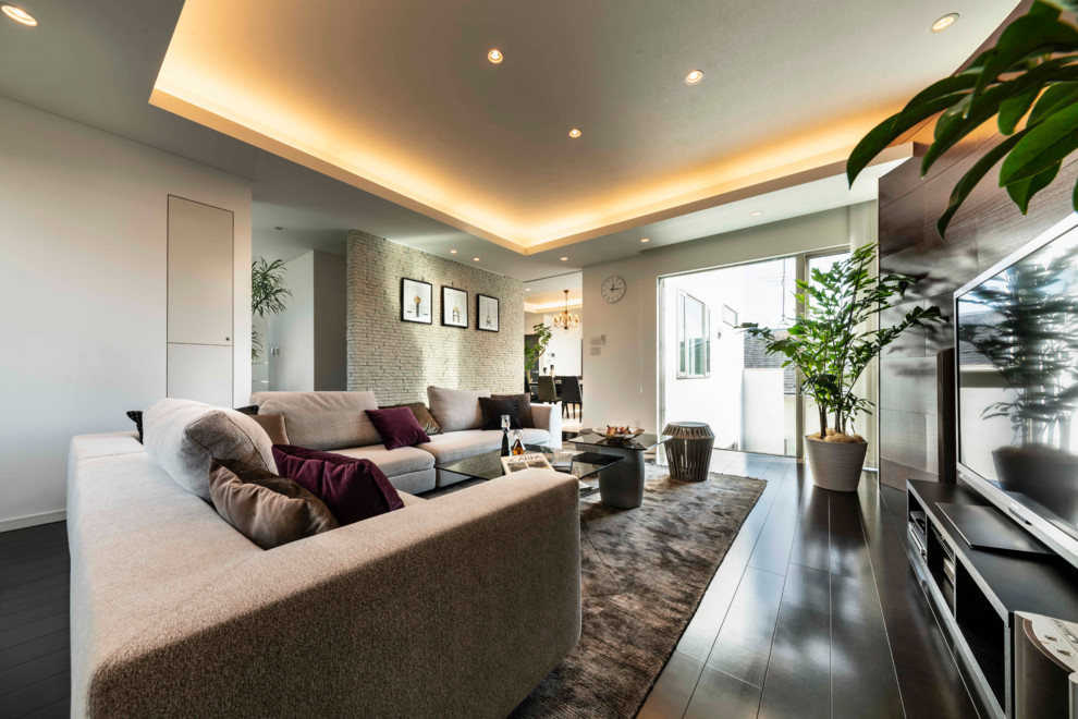 Großes, Offenes Modernes Wohnzimmer mit weißer Wandfarbe, Sperrholzboden, freistehendem TV und braunem Boden in Sonstige