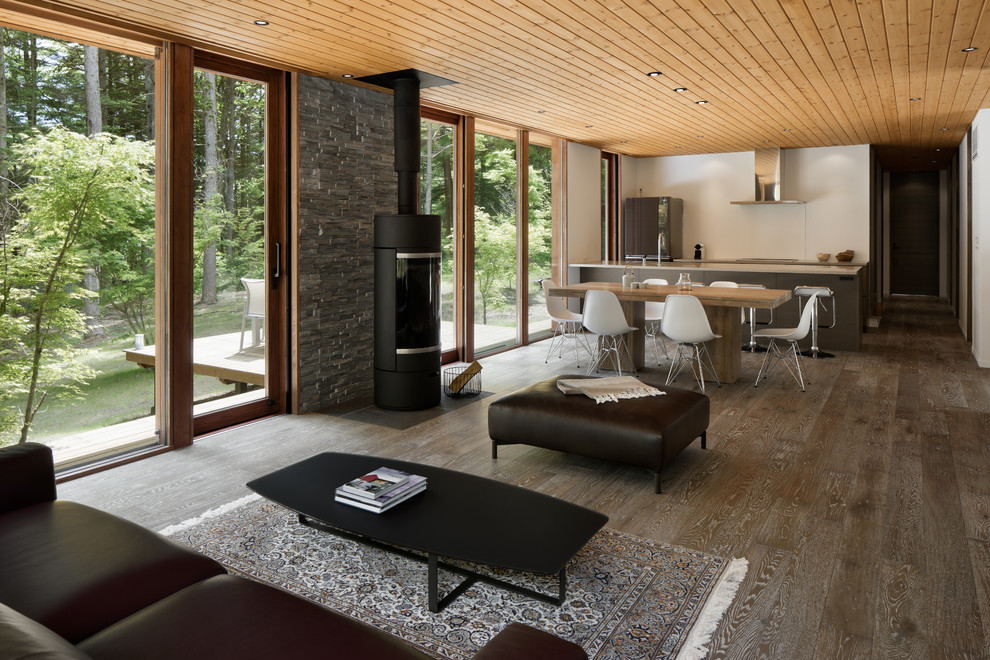 На фото: открытая гостиная комната в стиле ретро с белыми стенами, деревянным полом и коричневым полом с