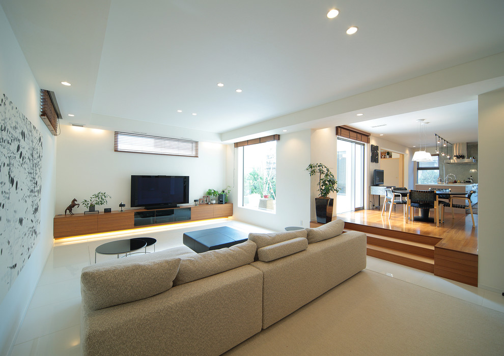 Идея дизайна: открытая гостиная комната в стиле модернизм с белыми стенами и отдельно стоящим телевизором