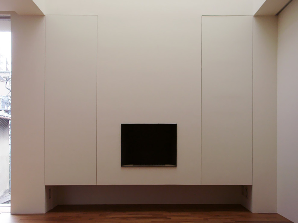 Example of a minimalist medium tone wood floor living room design in Tokyo with a standard fireplace, a wood fireplace surround and white walls