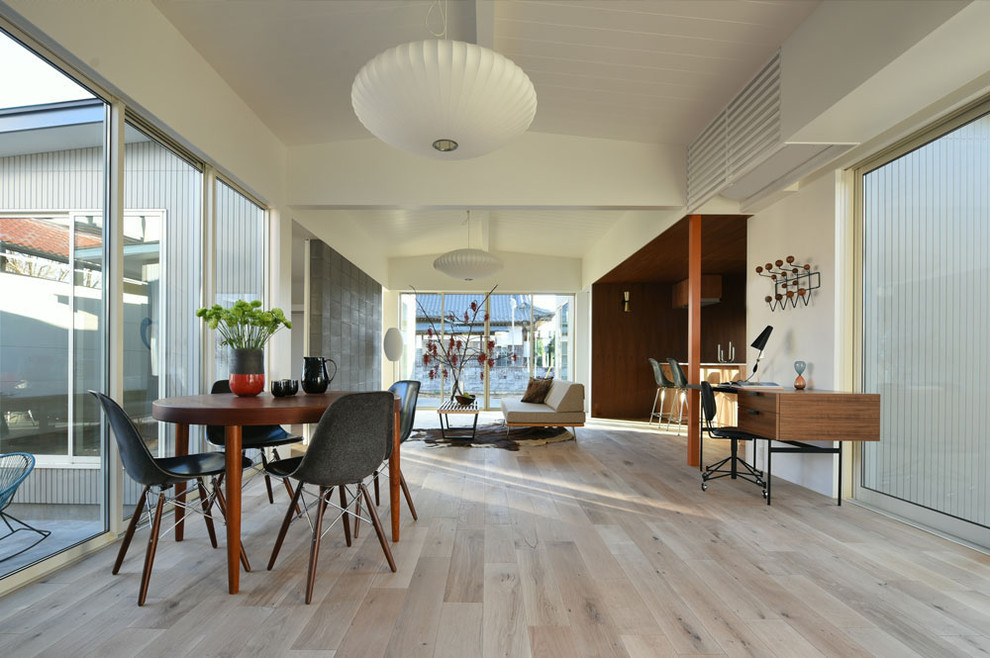 Стильный дизайн: открытая гостиная комната среднего размера в стиле ретро с белыми стенами, светлым паркетным полом, отдельно стоящим телевизором и серым полом - последний тренд