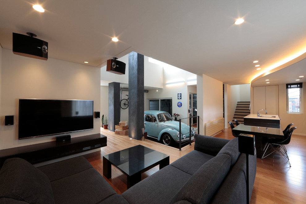 Foto di un soggiorno contemporaneo di medie dimensioni e aperto con pareti bianche, nessun camino, TV a parete, pavimento marrone e pavimento in legno massello medio