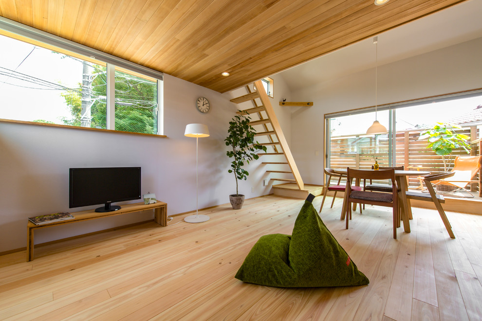 На фото: гостиная комната среднего размера в скандинавском стиле с белыми стенами, светлым паркетным полом и бежевым полом с