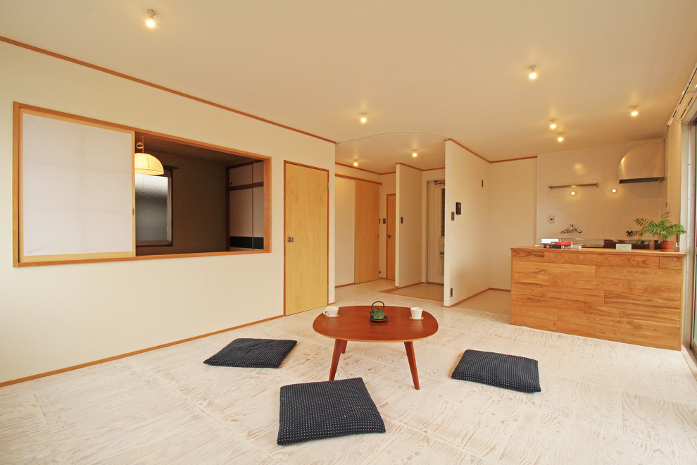Ejemplo de salón abierto de estilo zen con suelo beige y paredes blancas