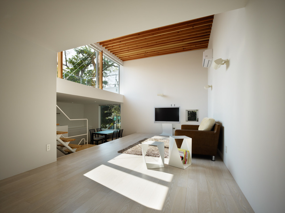 Источник вдохновения для домашнего уюта: гостиная комната в восточном стиле с белыми стенами, деревянным полом, отдельно стоящим телевизором и бежевым полом