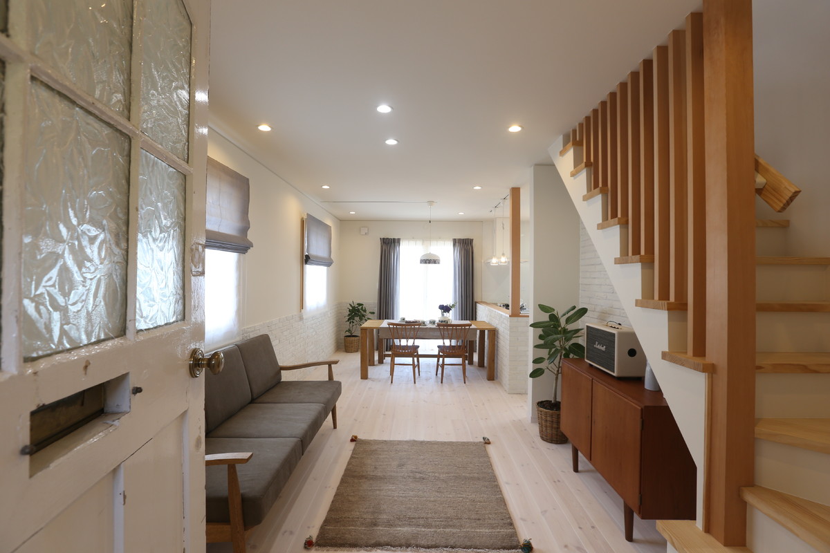 Offenes Skandinavisches Wohnzimmer mit weißer Wandfarbe, hellem Holzboden und weißem Boden in Sonstige